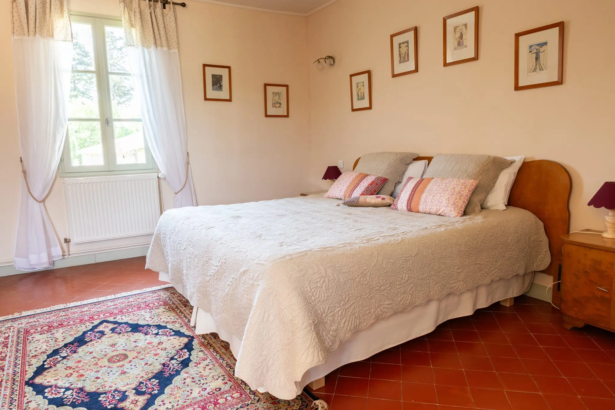 Chambre d'hôtes dans une bastide, tomettes, tapis ancien et lit en bois clair