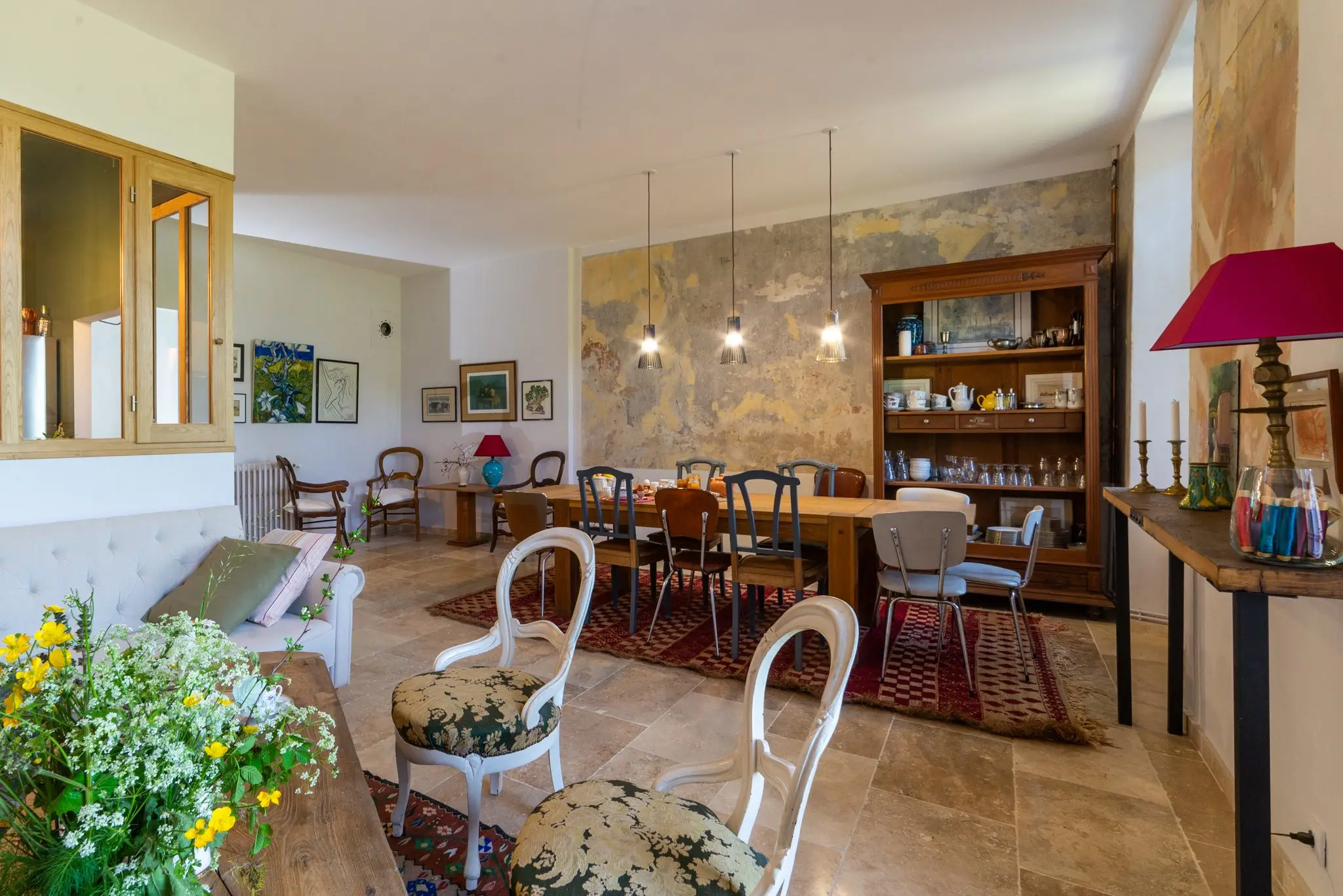 Salle commune d'une maison d'hôtes, tables d'hôtes, bibliothèque et suspensions