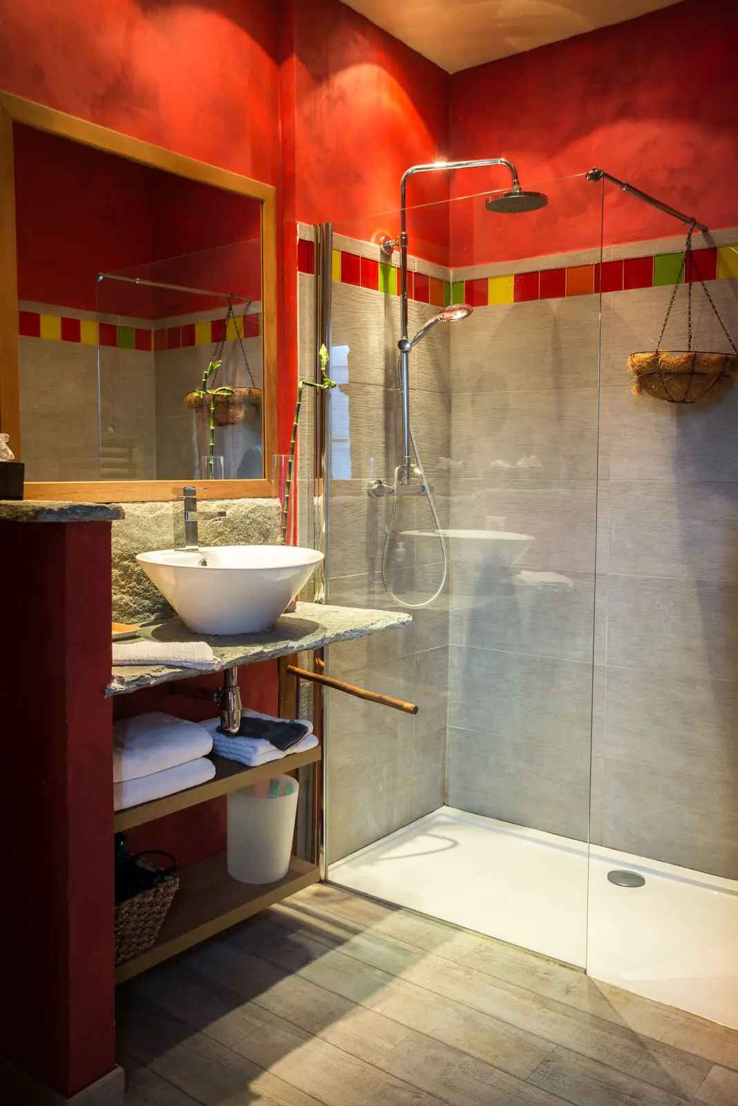 Salle de douche d'une chambre d'hôtes, vasque blanche sur plateau en pierre et paroi vitrée