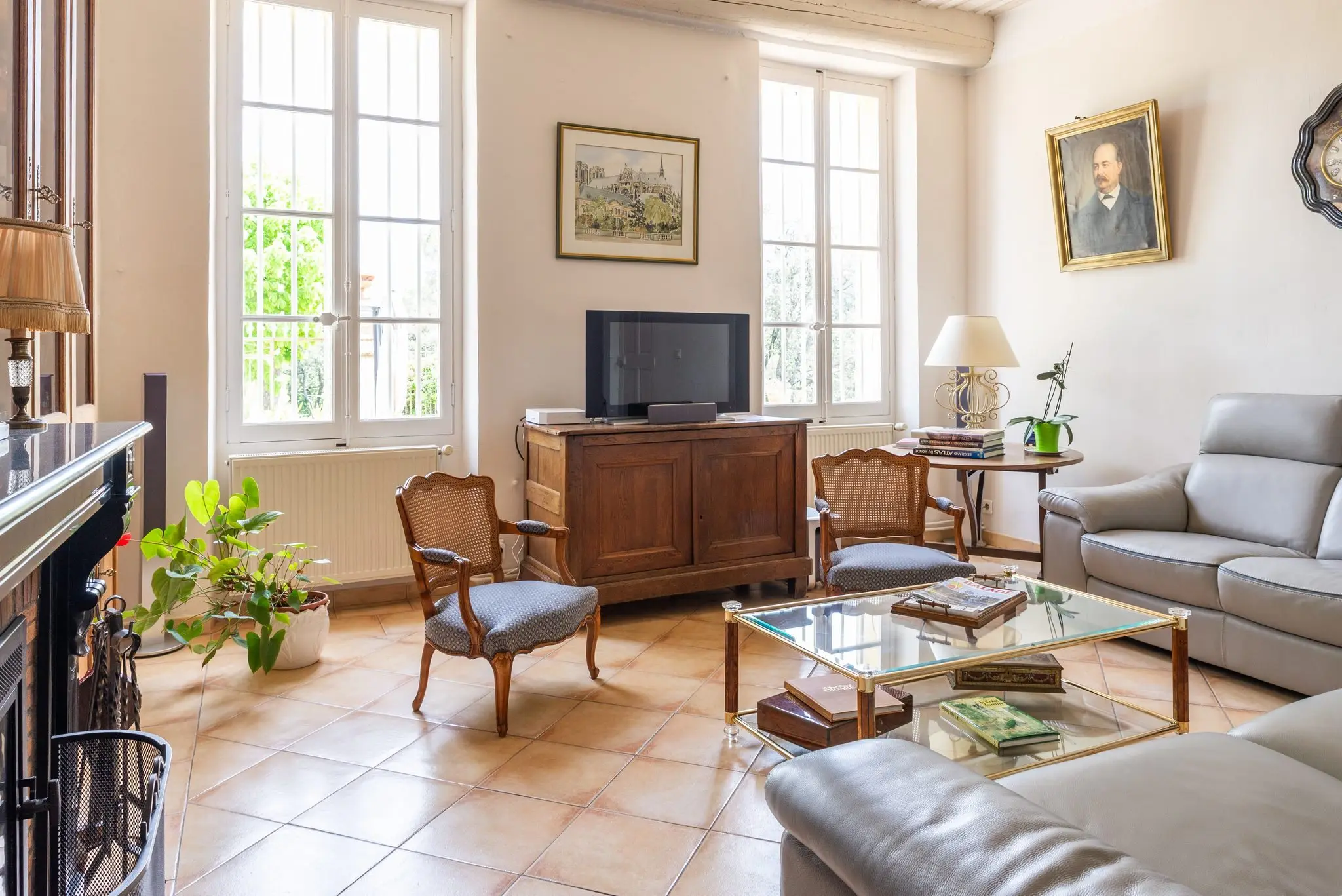 Salon d’une bastide en pierre, tomettes et hautes fenêtres